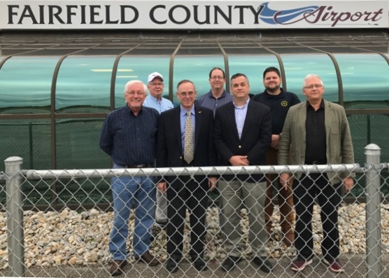 Fairfield County Board Members group of men standing together in front of airport signage