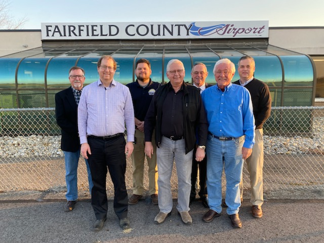 Fairfield County Board Members group of men standing together in front of airport signage